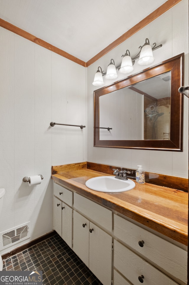 bathroom with toilet, vanity, and tile patterned floors