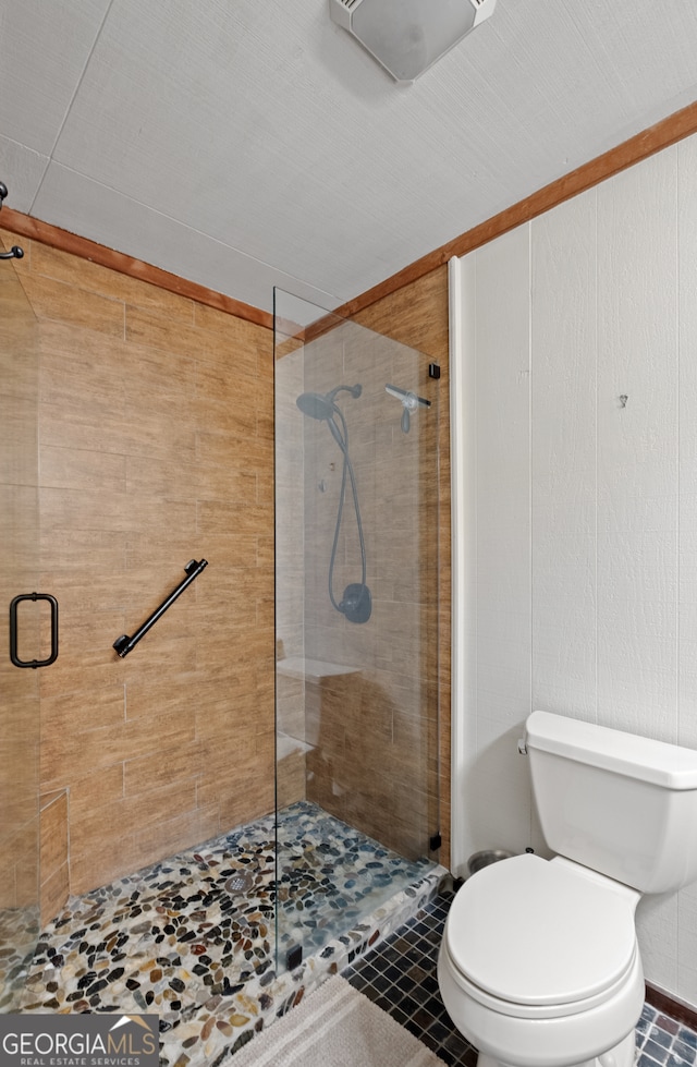 bathroom featuring toilet, tile patterned floors, and a shower with shower door