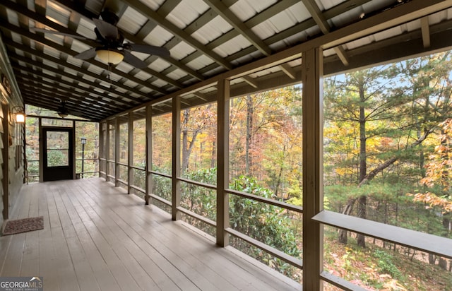 unfurnished sunroom featuring lofted ceiling, ceiling fan, and plenty of natural light