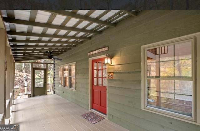 doorway to property featuring covered porch and ceiling fan