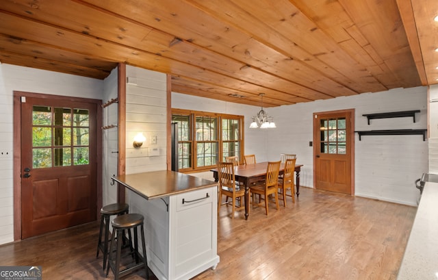 kitchen featuring light wood-type flooring, pendant lighting, a wealth of natural light, and white cabinets