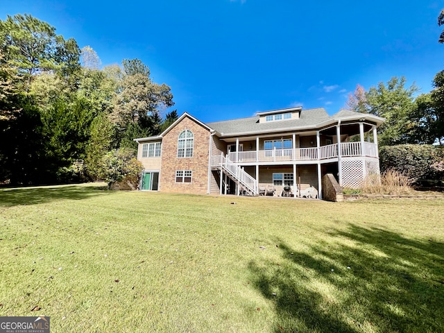 back of property with a yard and a wooden deck