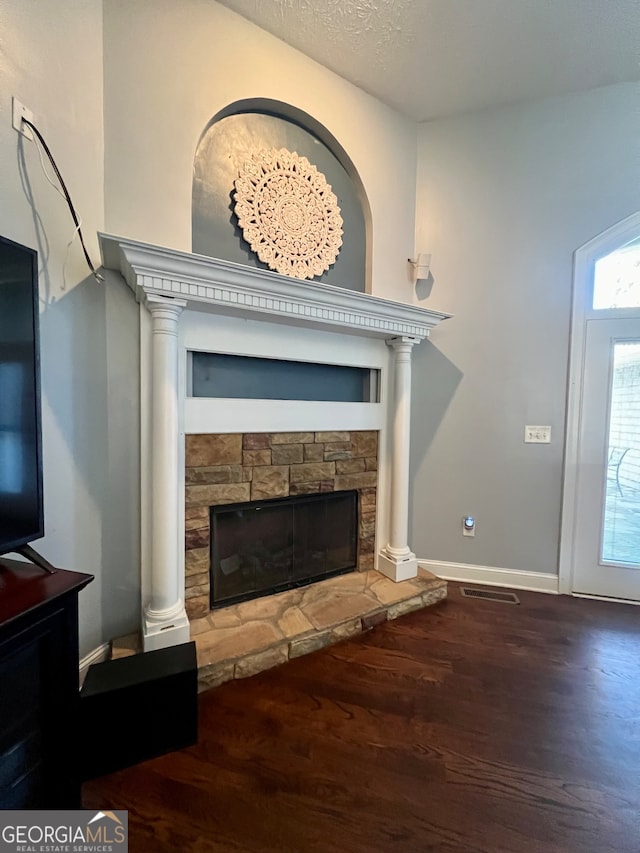 living room with dark hardwood / wood-style flooring, a textured ceiling, and a fireplace