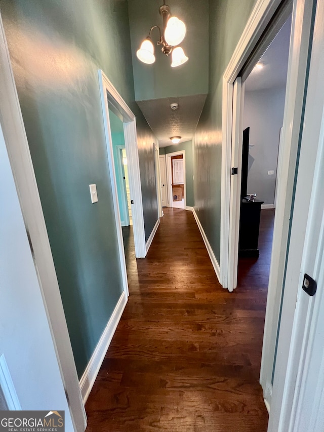 hall with an inviting chandelier and dark hardwood / wood-style floors