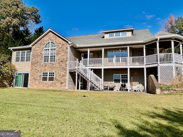 rear view of property featuring a deck, a yard, and a patio area