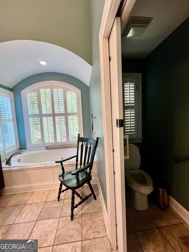 bathroom featuring tile patterned floors, toilet, and a bathing tub