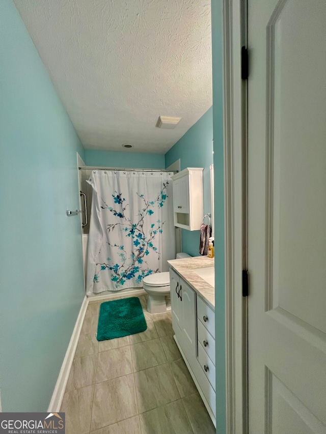 bathroom featuring tile patterned flooring, vanity, toilet, and a textured ceiling