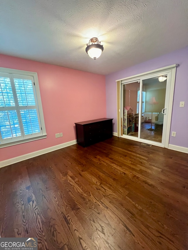 spare room featuring a textured ceiling and hardwood / wood-style flooring