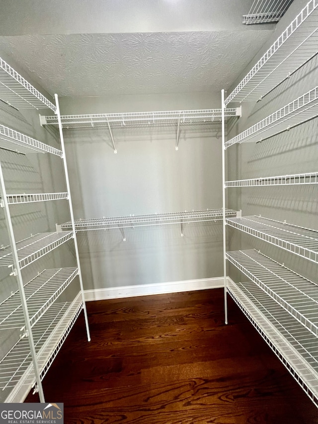 walk in closet with hardwood / wood-style flooring