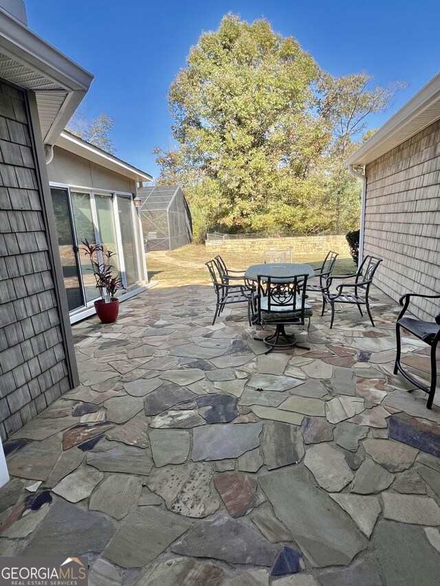 view of yard featuring glass enclosure and a patio area