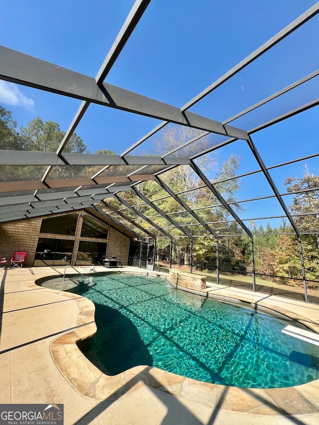 view of swimming pool with a patio area and a lanai