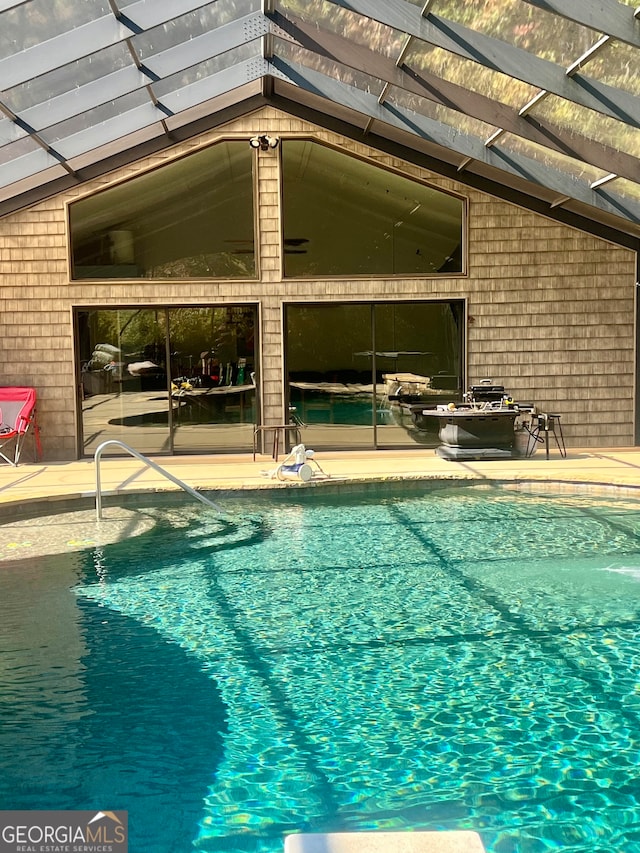 view of swimming pool with a lanai and a patio