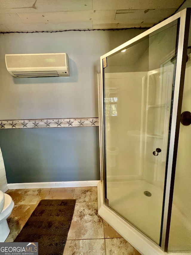 bathroom featuring a wall mounted AC, a shower with door, and toilet