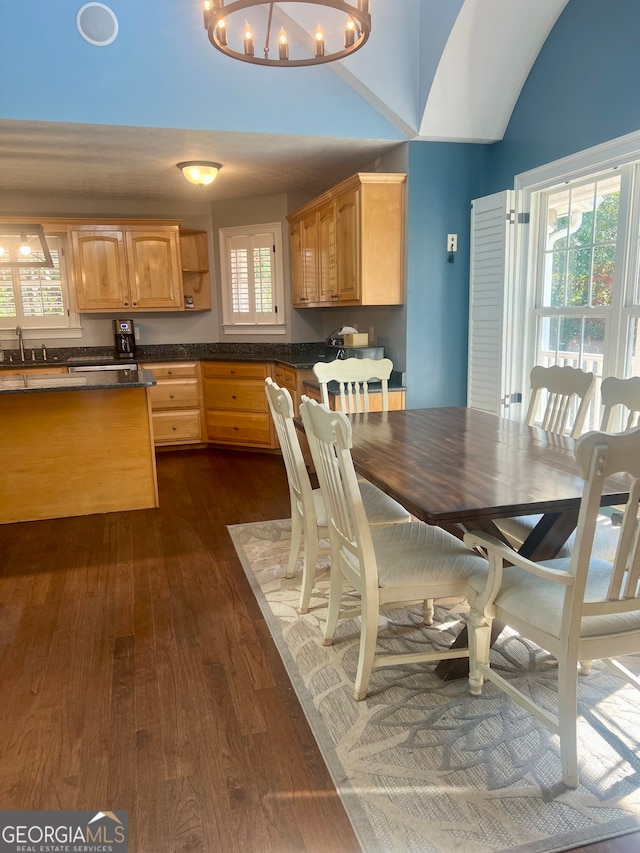 kitchen featuring dark wood-type flooring, an inviting chandelier, light brown cabinetry, and pendant lighting