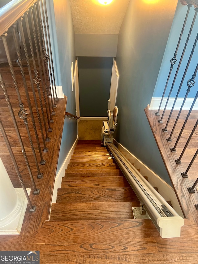 stairway featuring hardwood / wood-style floors and a textured ceiling