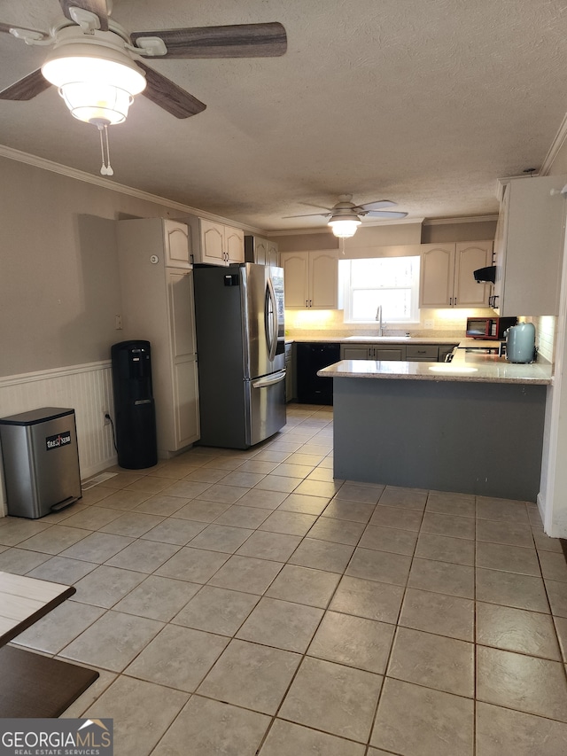 kitchen with kitchen peninsula, stainless steel refrigerator, white cabinetry, and sink