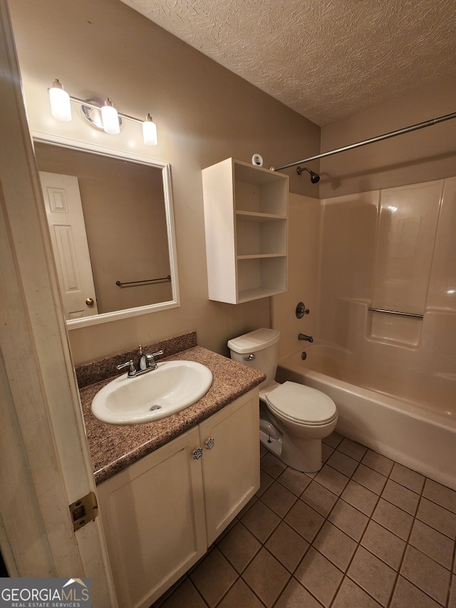 full bathroom featuring tile patterned flooring, vanity, toilet, and a textured ceiling