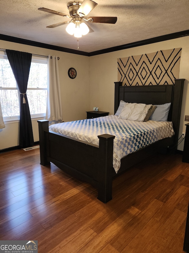 bedroom featuring hardwood / wood-style floors, ceiling fan, crown molding, and a textured ceiling