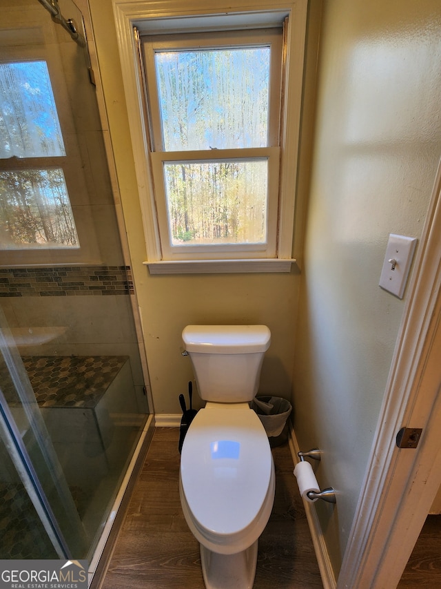 bathroom featuring hardwood / wood-style flooring, toilet, and walk in shower