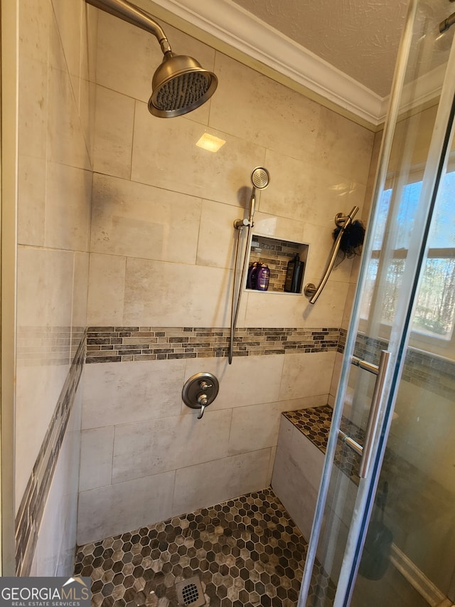 bathroom featuring tiled shower, a textured ceiling, and crown molding