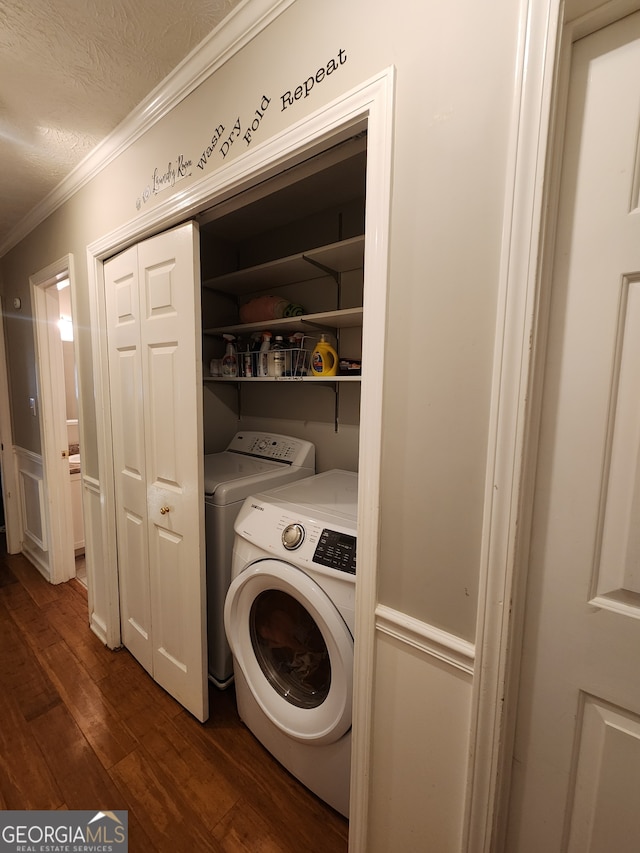 clothes washing area with a textured ceiling, separate washer and dryer, dark hardwood / wood-style floors, and ornamental molding