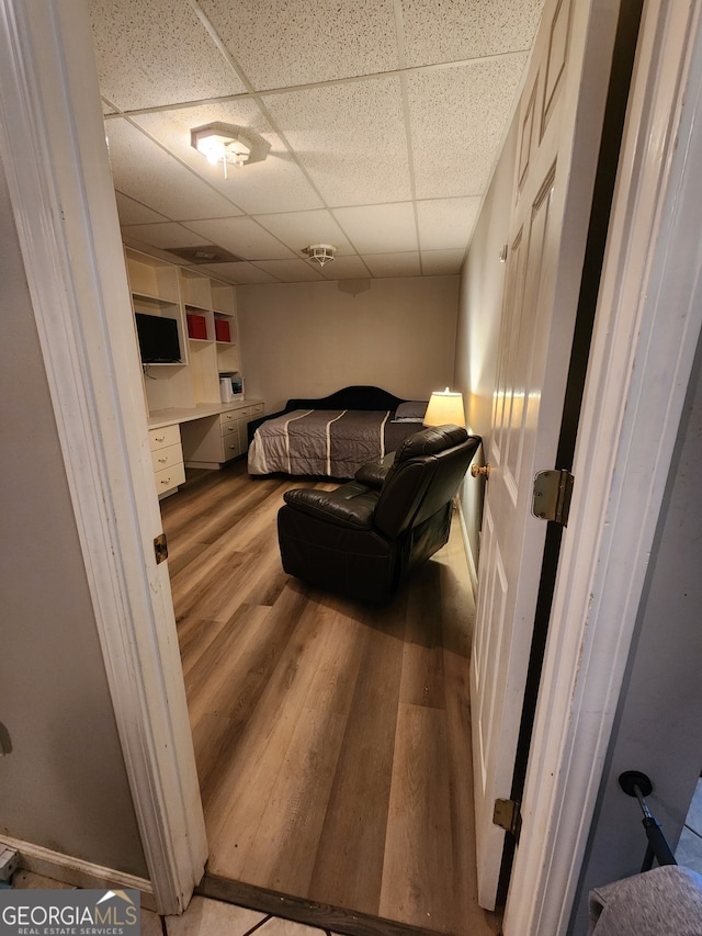 bedroom featuring a paneled ceiling and hardwood / wood-style flooring