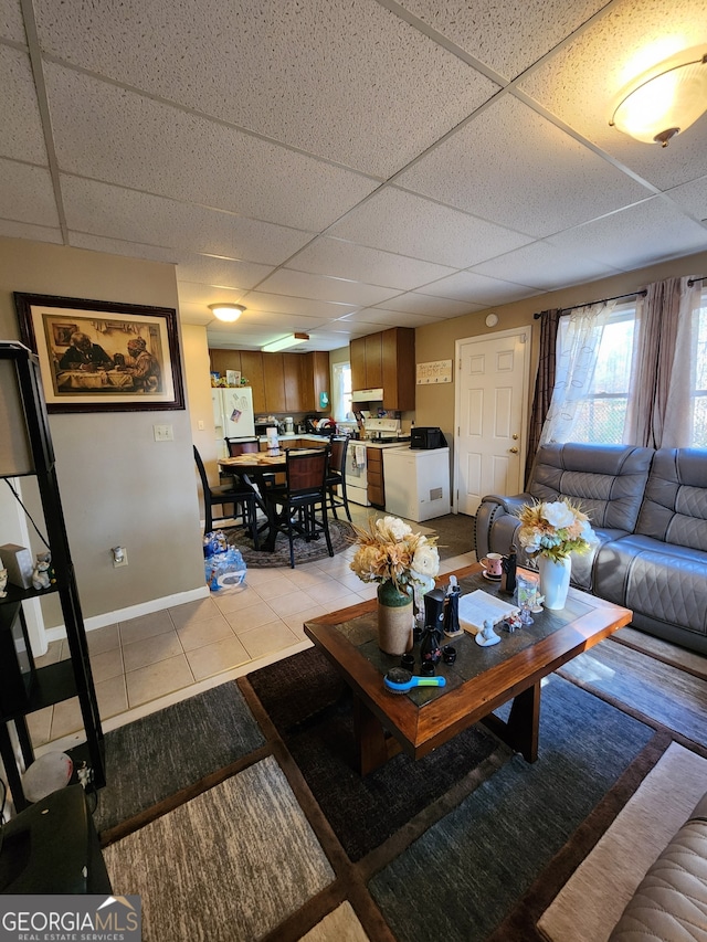 living room featuring a drop ceiling and light tile patterned flooring