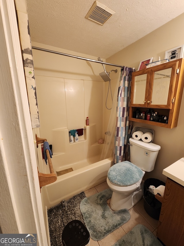 full bathroom with tile patterned floors, vanity, a textured ceiling, shower / bath combo with shower curtain, and toilet