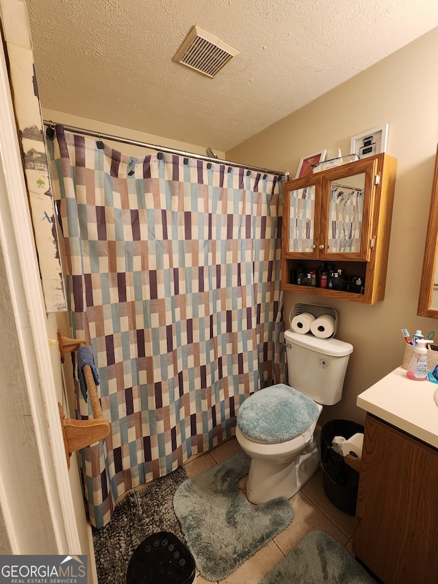 bathroom with walk in shower, tile patterned floors, a textured ceiling, toilet, and vanity