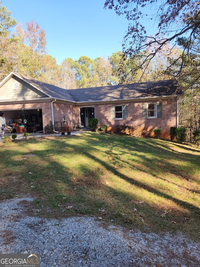 back of house featuring a lawn and a garage