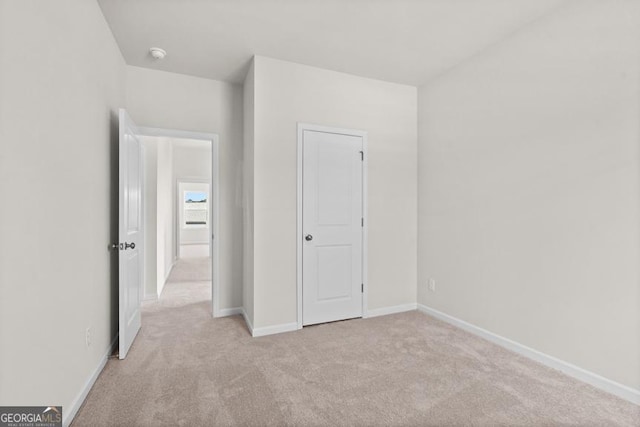 unfurnished bedroom featuring light carpet