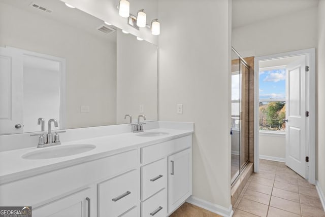 bathroom with tile patterned floors, vanity, and an enclosed shower