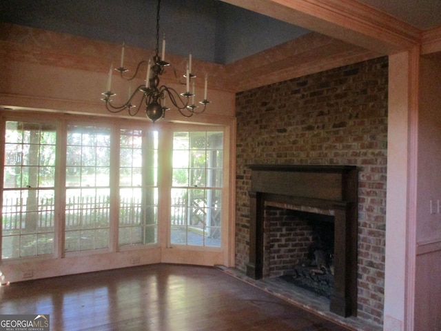 unfurnished living room featuring a brick fireplace, plenty of natural light, and hardwood / wood-style flooring