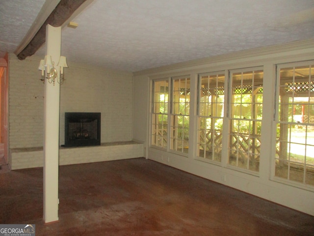 unfurnished living room with dark carpet, a textured ceiling, a notable chandelier, beam ceiling, and a large fireplace