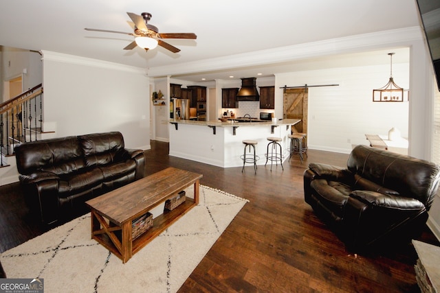 unfurnished bedroom featuring a raised ceiling, ceiling fan, dark wood-type flooring, crown molding, and a barn door