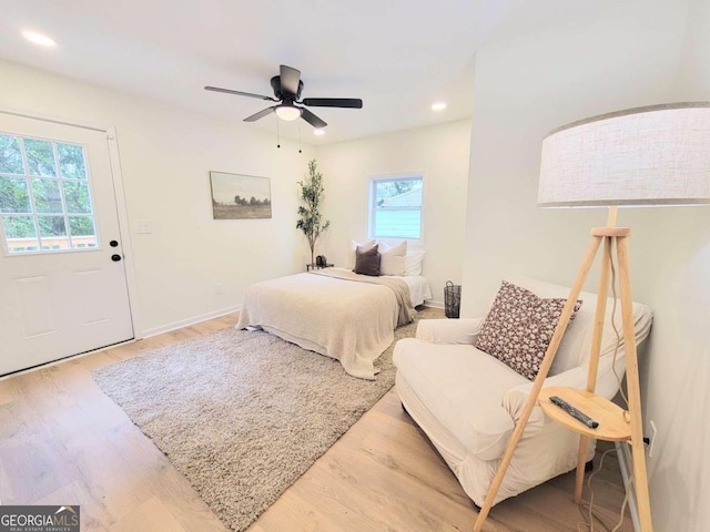 bedroom featuring multiple windows, hardwood / wood-style flooring, and ceiling fan