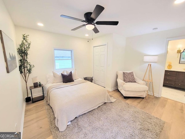 bedroom featuring ceiling fan, connected bathroom, a closet, and light wood-type flooring