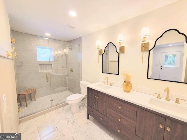 bathroom with toilet, vanity, and a shower with door