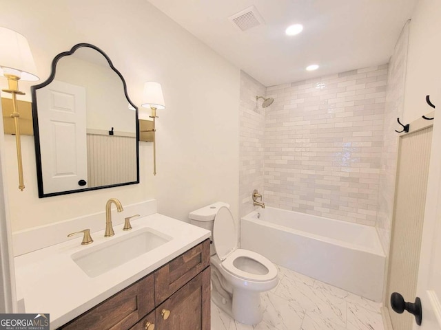 full bathroom with toilet, vanity, and tiled shower / bath