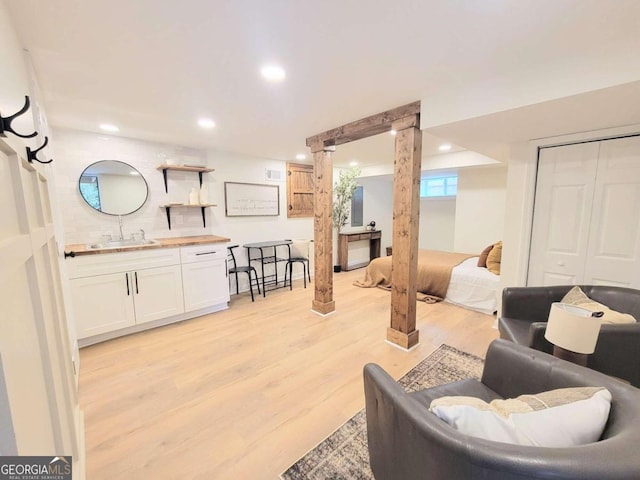 living room featuring wet bar and light hardwood / wood-style floors