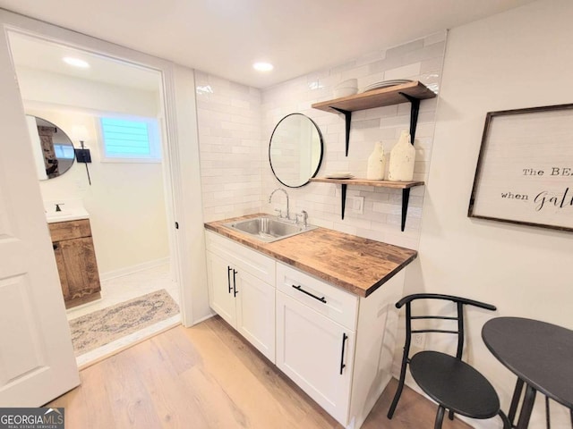 bathroom featuring wood-type flooring, tasteful backsplash, and vanity