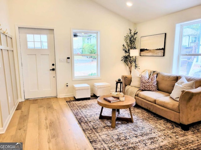 living room featuring light wood-type flooring and lofted ceiling