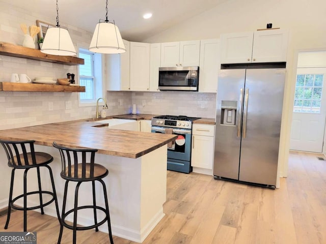 kitchen featuring a wealth of natural light, pendant lighting, appliances with stainless steel finishes, and white cabinets