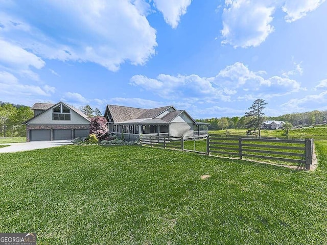 view of yard with a garage and a rural view