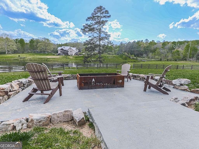 view of patio featuring an outdoor fire pit, a water view, and a rural view