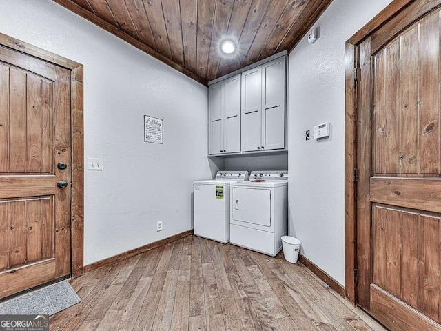 laundry area featuring cabinets, light wood-type flooring, washer and clothes dryer, and wooden ceiling