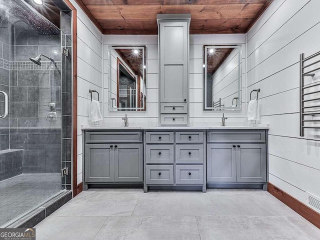 bathroom featuring wooden ceiling, a shower with door, vanity, and wooden walls