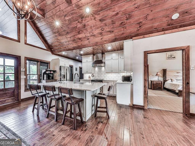 42 Lone Pine Dr, Morganton, GA 30560 - kitchen featuring wall chimney exhaust hood, wood ceiling, dark wood-type flooring, a sink, and a kitchen breakfast bar
