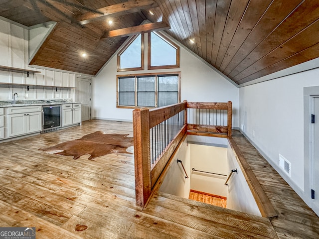 bonus room with light hardwood / wood-style floors, wood ceiling, sink, beamed ceiling, and wine cooler