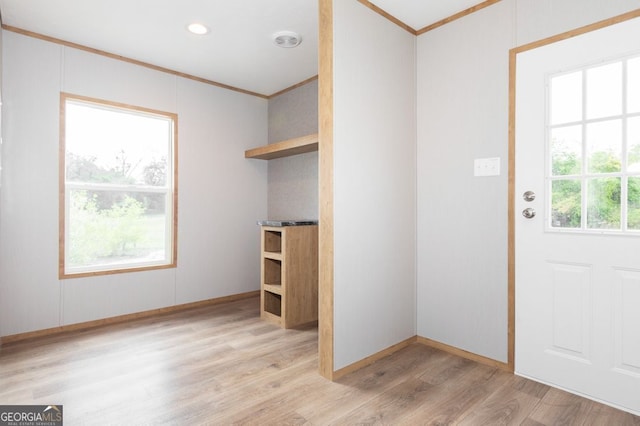 interior space with crown molding and light hardwood / wood-style flooring